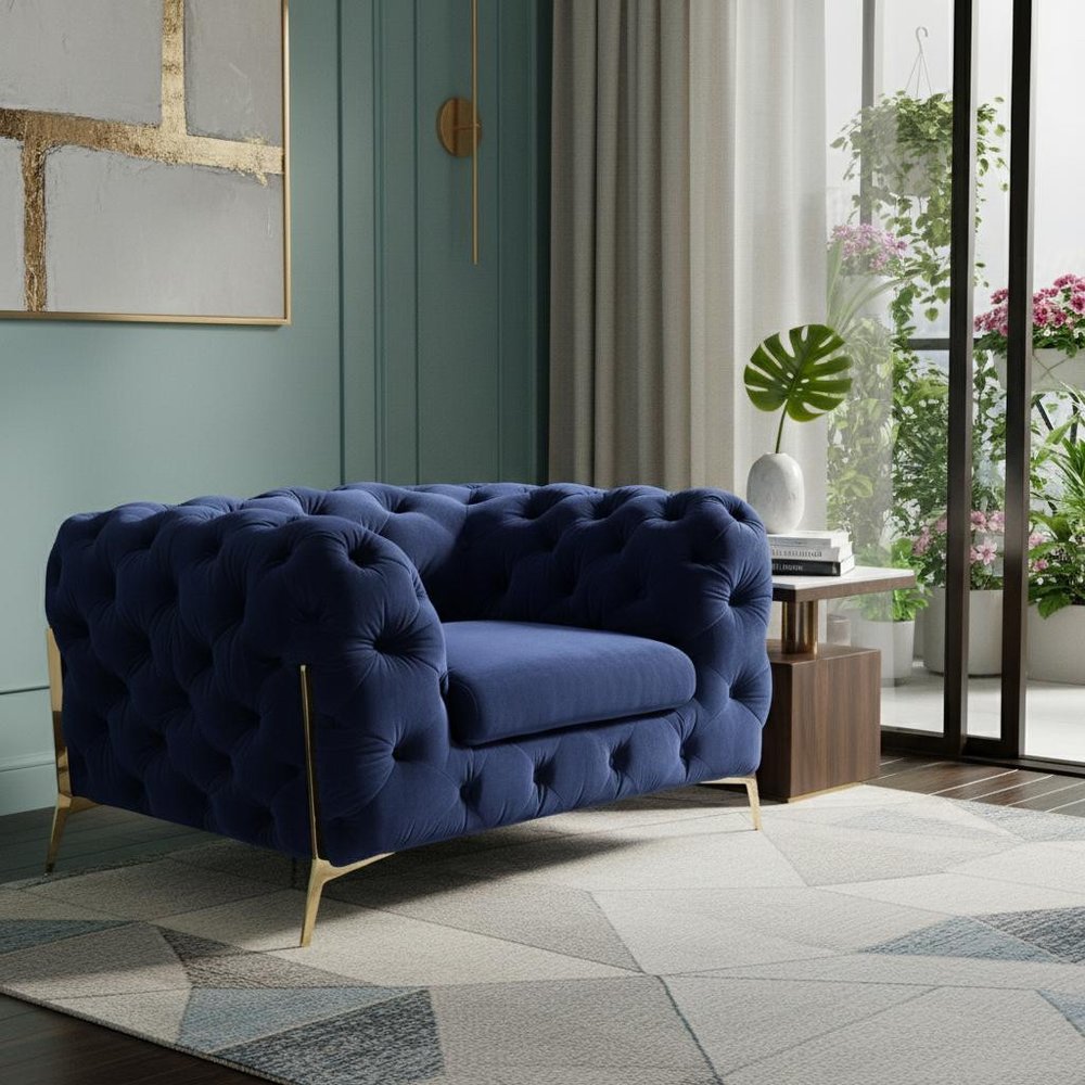 50" Blue And Gold Velvet Tufted Lounge Chair styled in a furnished interior on a tiled floor against a gray wall.