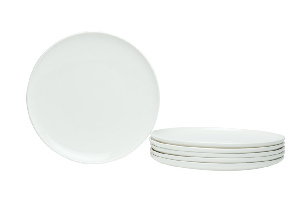 Stack of six white porcelain salad plates with one plate to the left on a white background.