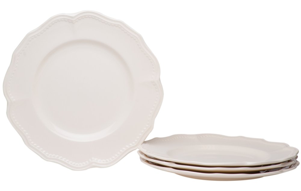 A white scallop stoneware dinner plate set with a beaded rim, with one plate in the foreground and three stacked behind it on a white background.