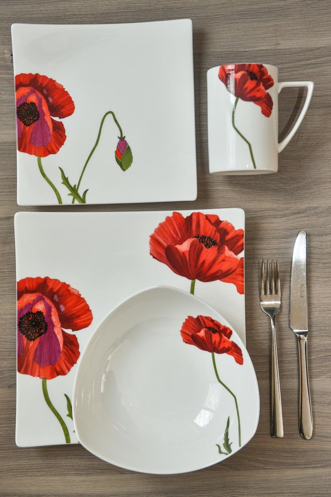 White bone china salad plates and mug with red poppy floral design on a wooden surface.