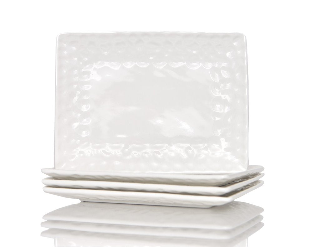Stack of white pebbled porcelain square dinner plates on a white background.