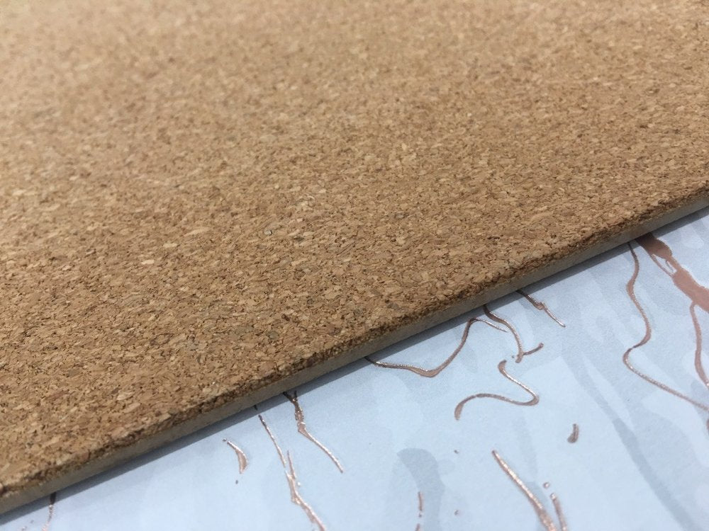 12" X 18" Gold And Silver Abstract Agglomerated cork Placemats styled in a furnished interior with a tan wall on a blue floor.
