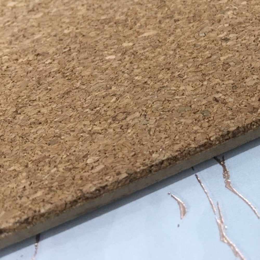 15" X 15" Gold Ivory And Gray Abstract Agglomerated cork Round Placemats styled in a furnished interior with a tan wall on a blue floor.