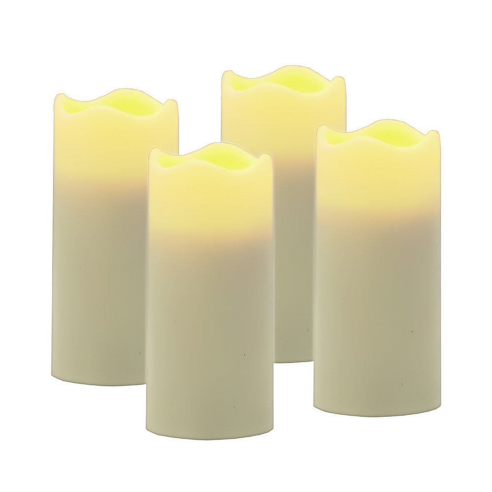 Set of four ivory flameless votive candles with wavy tops on a white background.