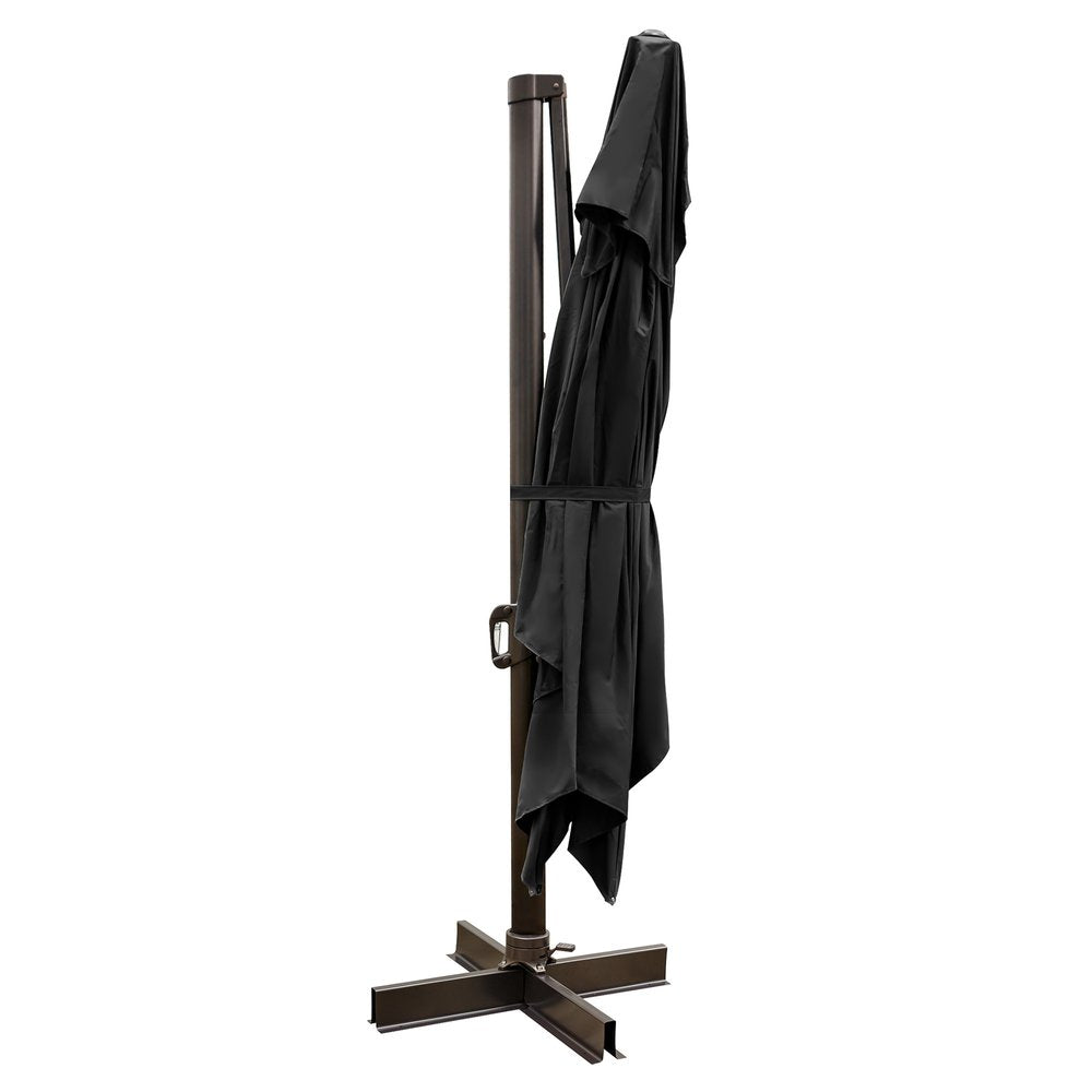 Black polyester cantilever patio umbrella folded and tied to a dark brown pole with a cross-shaped base on a white background.