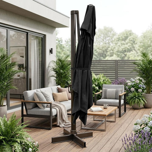 Black polyester cantilever patio umbrella with stand on a wooden deck with outdoor furniture and plants.
