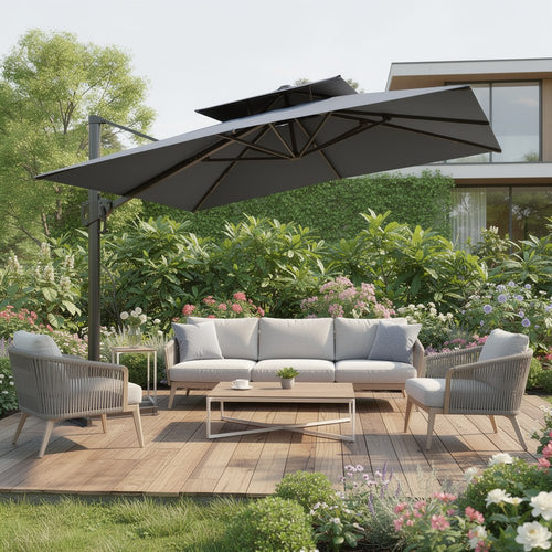 Gray cantilever patio umbrella over a light gray sofa, two chairs, and a coffee table on a wooden deck with lush green landscaping.
