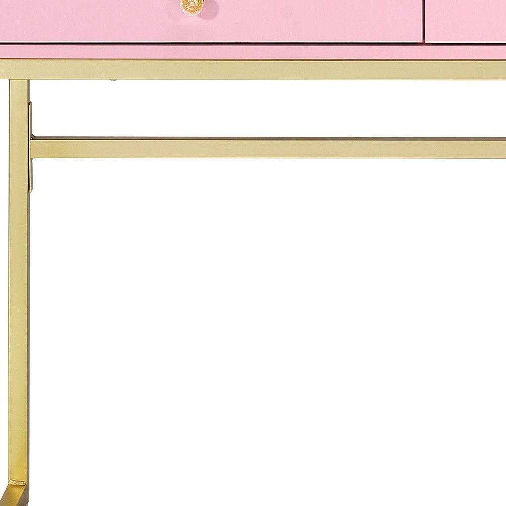 42" Gold And Pink Wood Vanity Table With Mirror And Two Drawers. Vanity table isolated on a plain white background, finished in gold wood.