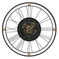 Black and gold metal analog wall clock with exposed gears and Roman numerals on a white background.