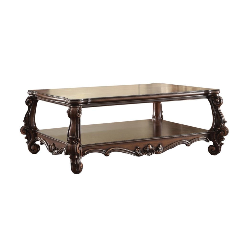 A dark brown wood coffee table with a shelf and ornate carved legs on a white background.