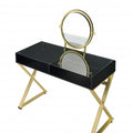 Black and gold mirrored vanity table with glass top and wooden drawers on a white background.
