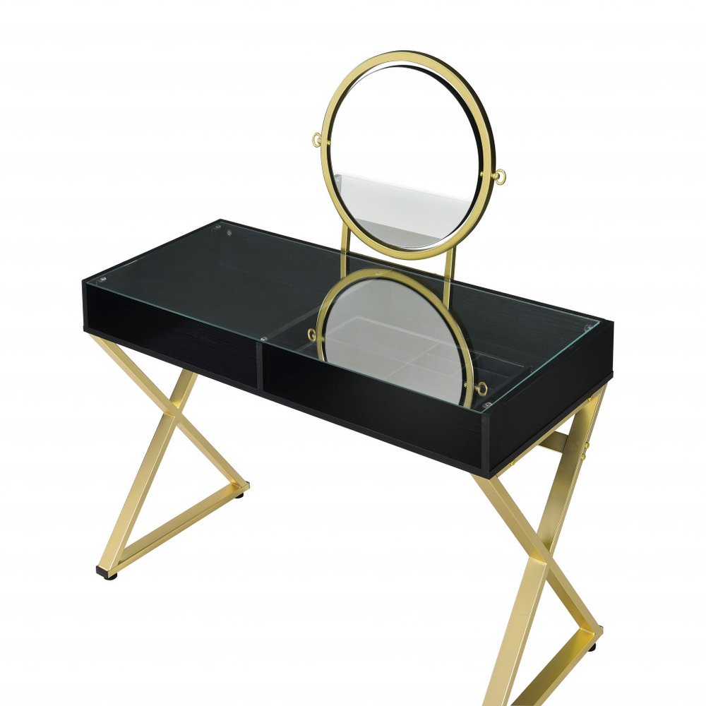 Black and gold mirrored vanity table with glass top and wooden drawers on a white background.