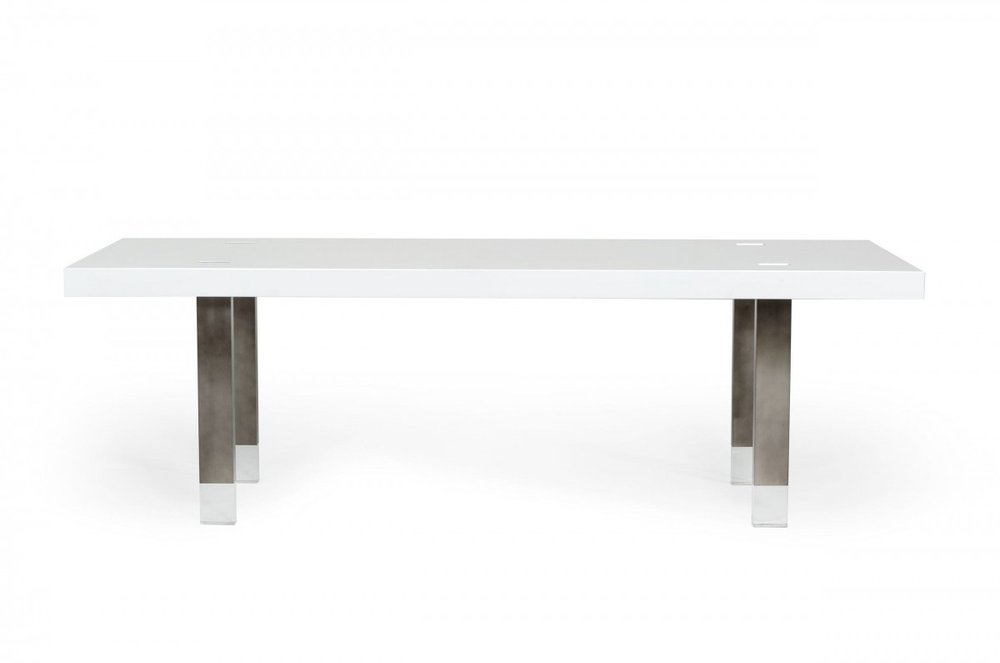White rectangular dining table with brushed stainless steel legs on a white background.