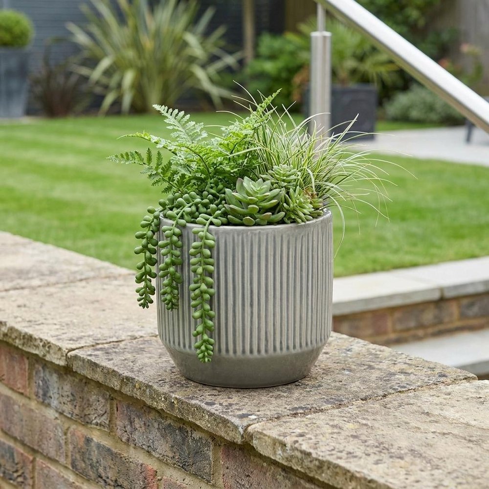 6" Gray Striped Ceramic Indoor Outdoor Round Pot Planter shown outdoors on a tiled patio with greenery.