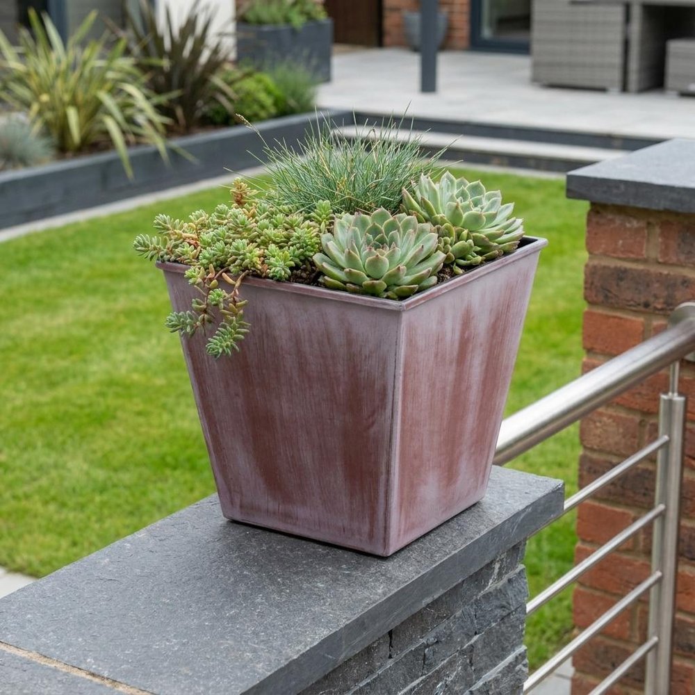 5" Brown and Off White Textural Tone On Tone Recycled Plastic Indoor Outdoor Square Pot Planter shown outdoors on a tiled patio with greenery.
