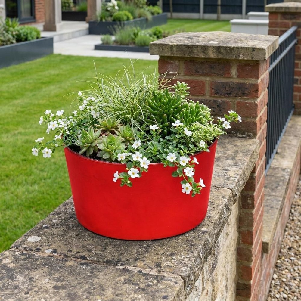 12" Red Recycled Plastic Indoor Outdoor Round Pot Planter - SKU 488307 shown outdoors on a patio with greenery.