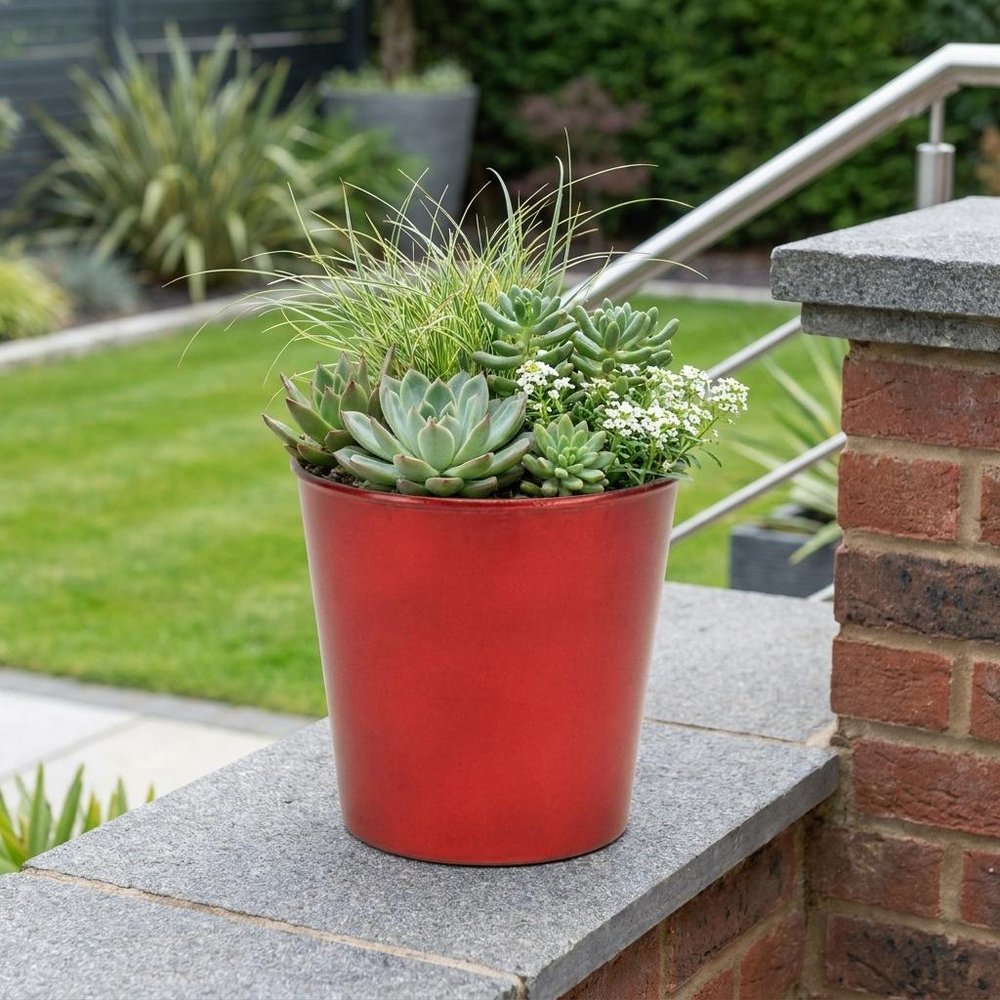 5" Red Recycled Plastic Indoor Outdoor Round Pot Planter shown outdoors on a tiled patio with greenery.