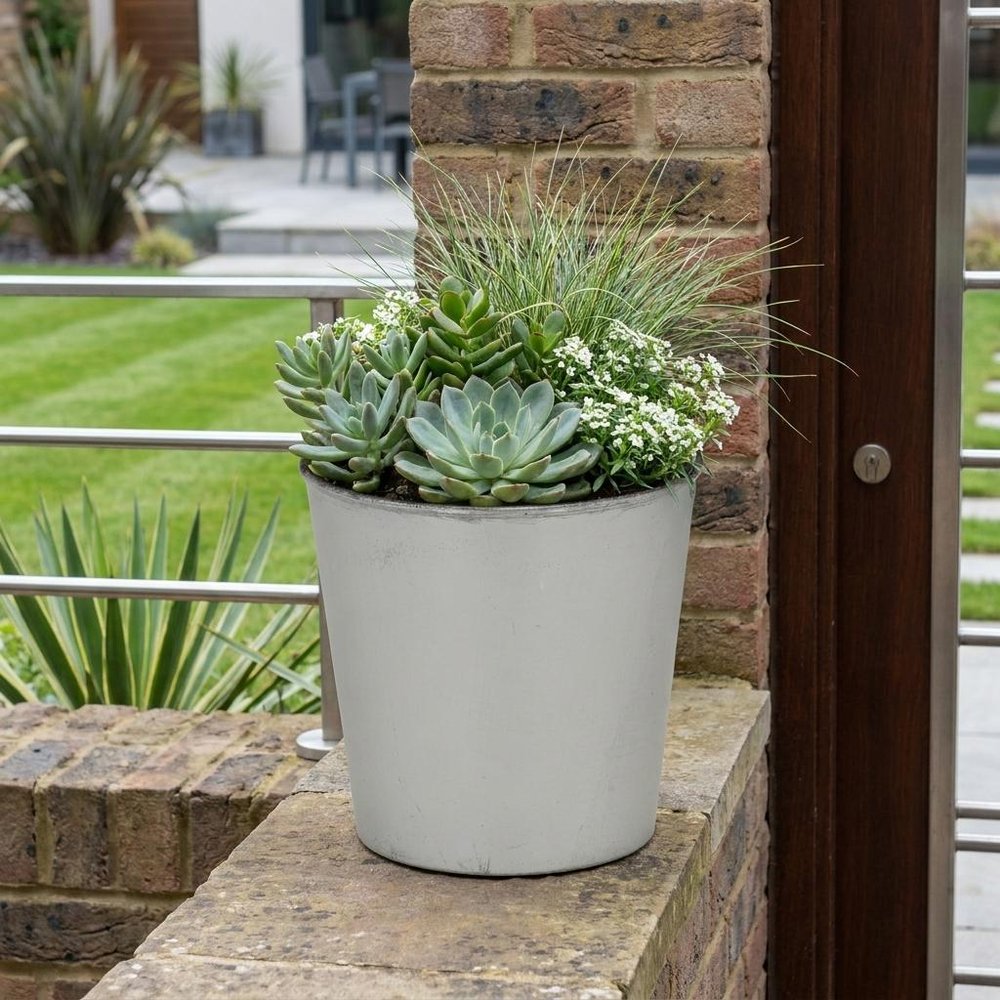 5" Silver Recycled Plastic Indoor Outdoor Round Pot Planter shown outdoors on a patio with greenery.