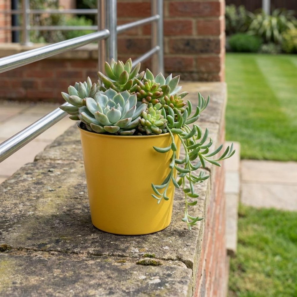 5" Yellow Recycled Plastic Indoor Outdoor Round Pot Planter shown outdoors on a patio with greenery.