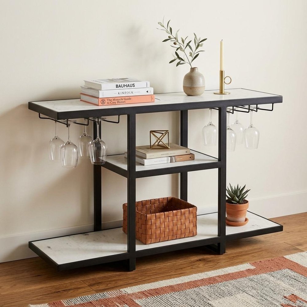 58" White and Black Genuine Marble Floor Shelf Console Table Two Shelves styled in a furnished interior with an off-white wall on a dark wood floor.