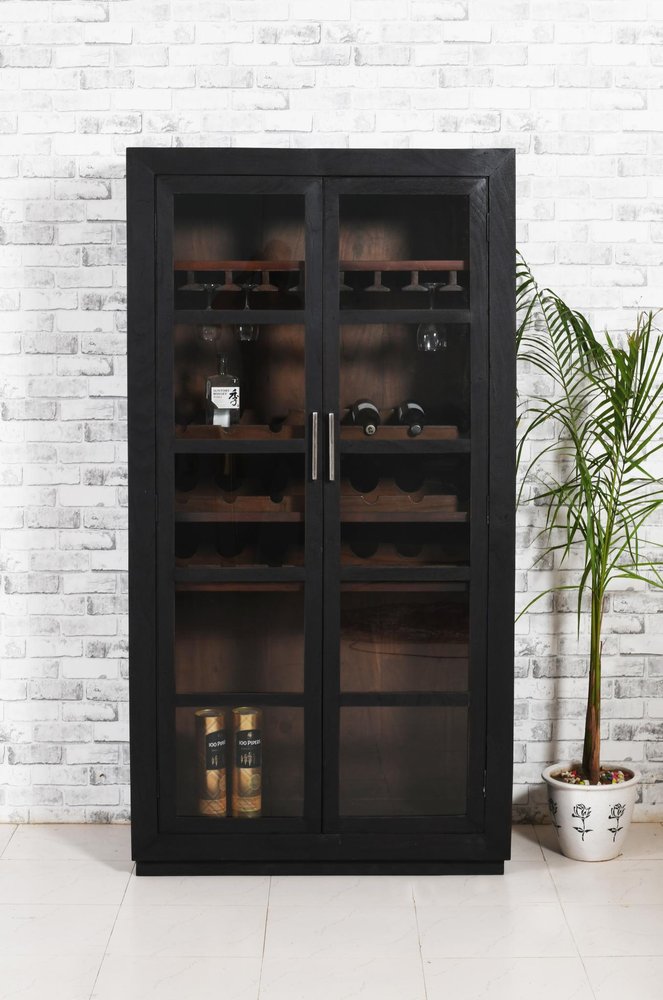 Dark gray distressed solid wood bar cabinet with glass doors, wine racks, and bottle storage against a white brick wall.