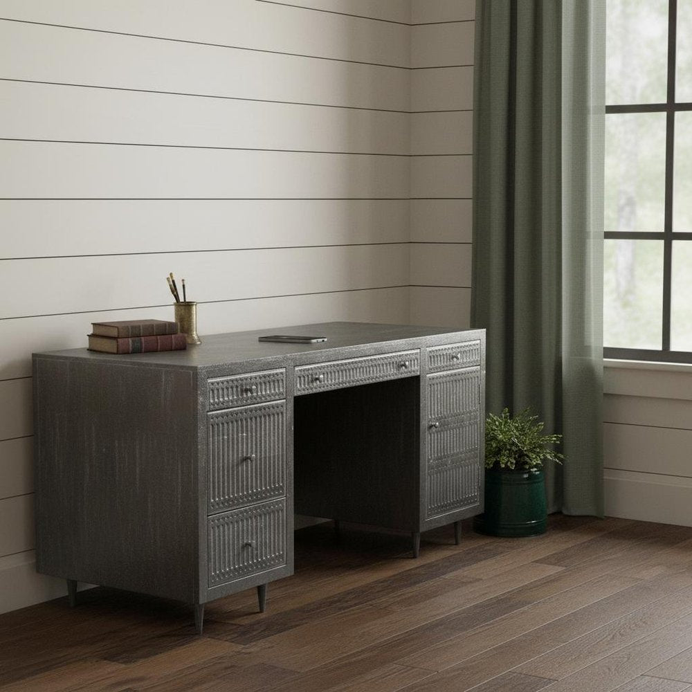 64" Brown and Silver Solid Wood Executive Desk With Five Drawers styled in a furnished interior with a light gray wall on a dark wood floor.