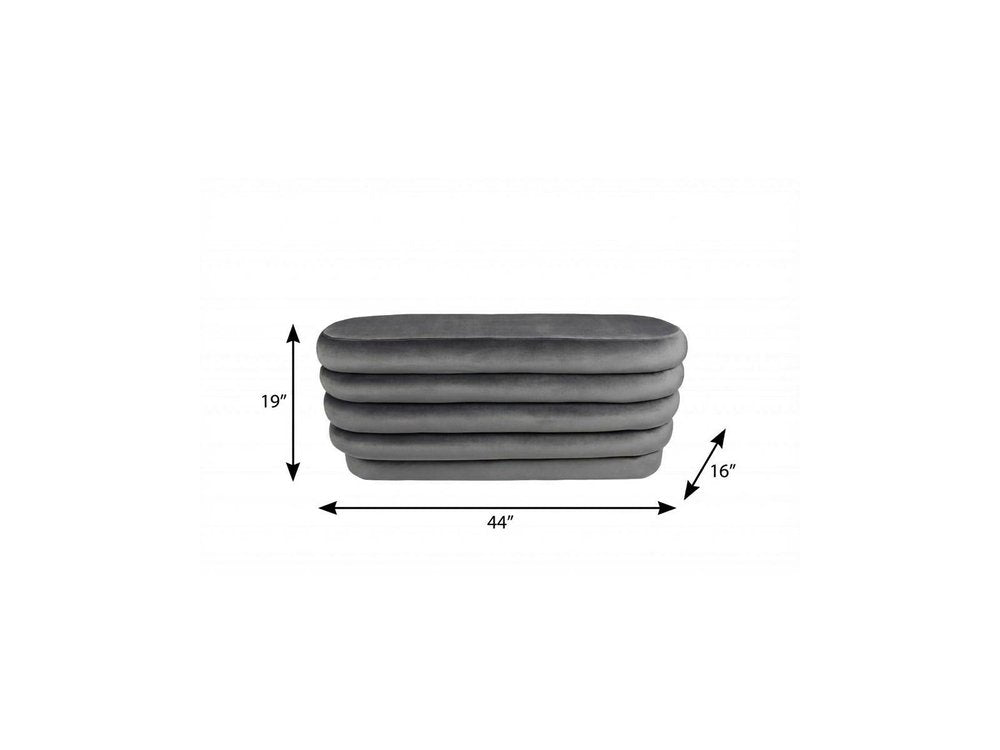 44" Gray Velvet Tufted Oval Ottoman. Ottoman isolated on a plain white background, showing a gray velvet surface.