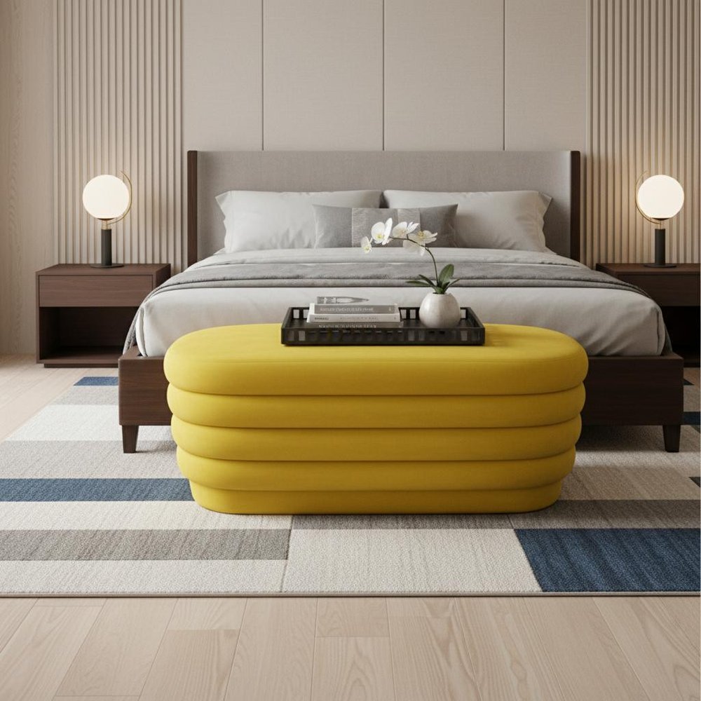 44" Yellow Velvet Tufted Oval Ottoman styled in a furnished interior with a tan wall on a wood floor.