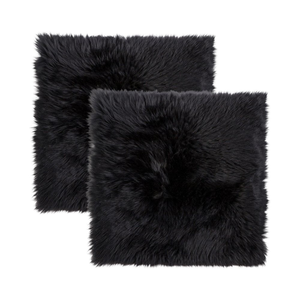 Two black wool chair pads with a fluffy texture on a white background.