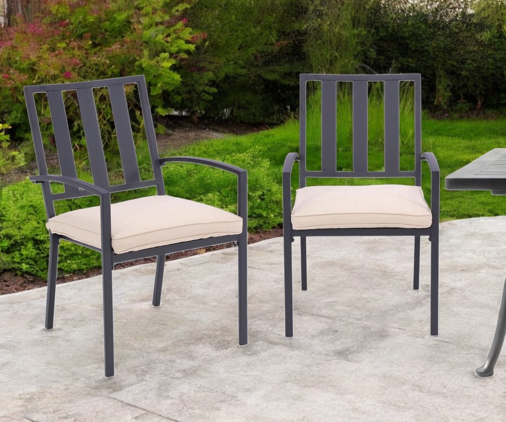 Set of Two Dark Gray Aluminum Outdoor Stacking Dining Chairs with Beige Cushion in a home interior
