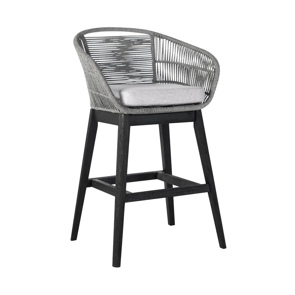 Gray woven outdoor bar stool with a light gray cushion and dark wood legs on a white background.