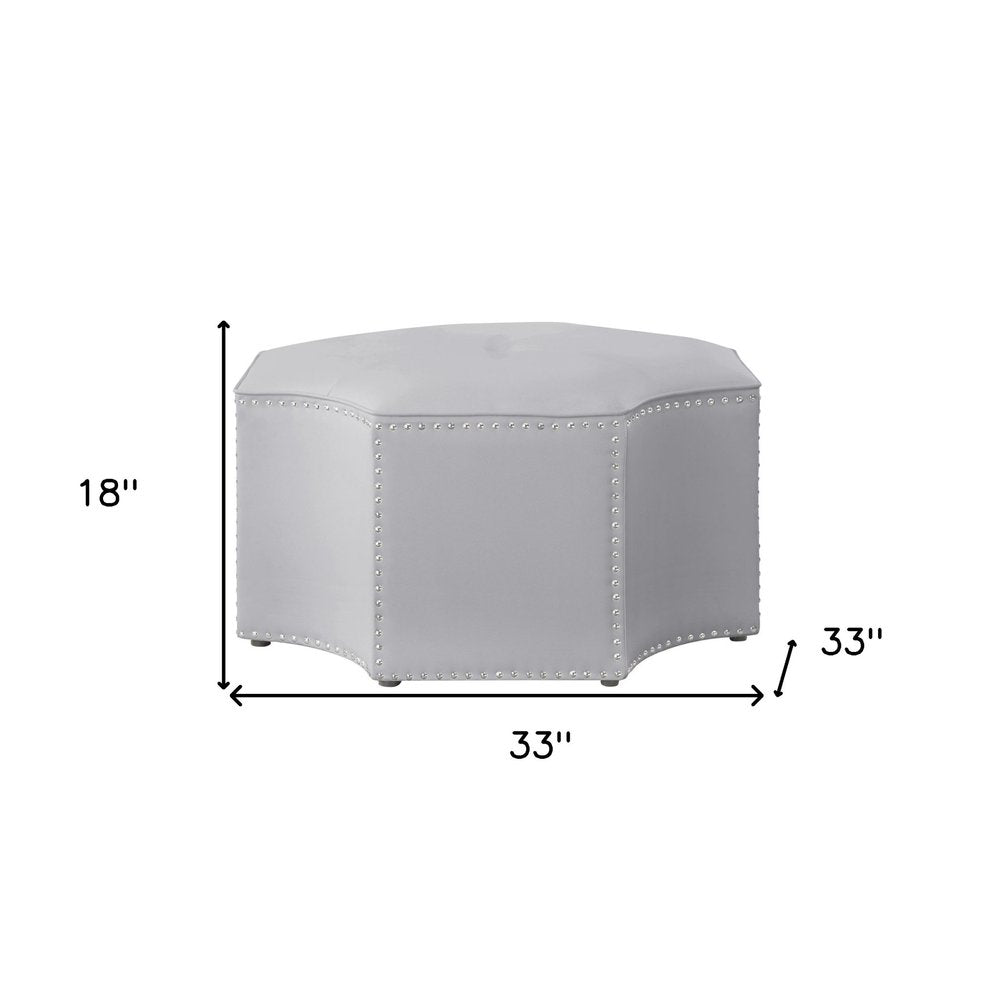 33" Silver Faux Leather Tufted Octagonal Cocktail Ottoman. Ottoman isolated on a plain white background, in a silver faux leather finish.