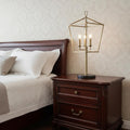 30" Black Iron Three Light Bedside Table Lamp displayed on a tabletop in a furnished interior against an off-white wall.
