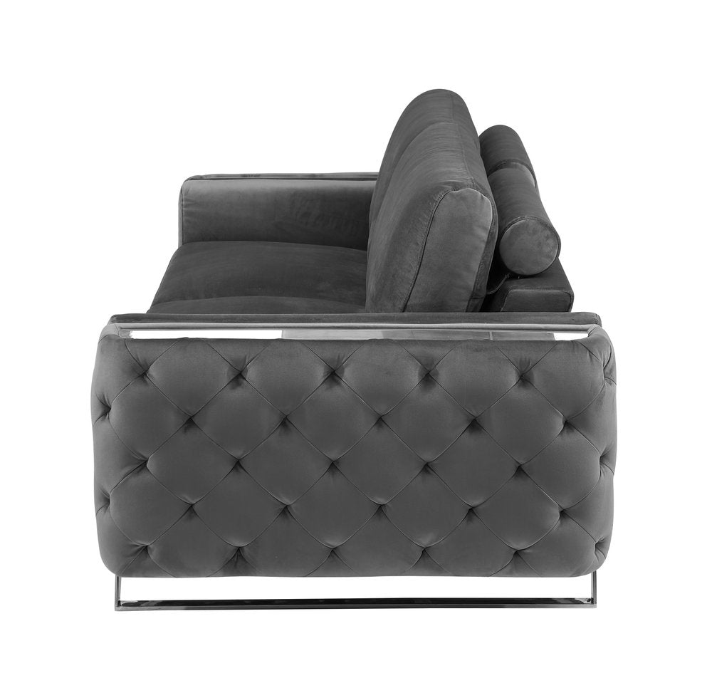 Gray velvet sofa with tufted detailing and silver legs, shown from the side against a white background.