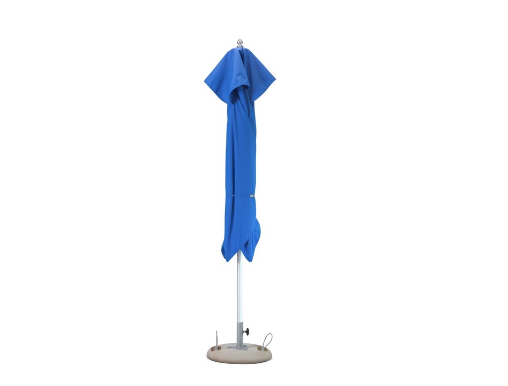 A closed blue polyester market patio umbrella with a silver pole and a beige base on a white background.