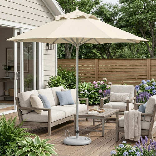 Ecru polyester patio umbrella with stand on a wooden deck with outdoor furniture and plants.
