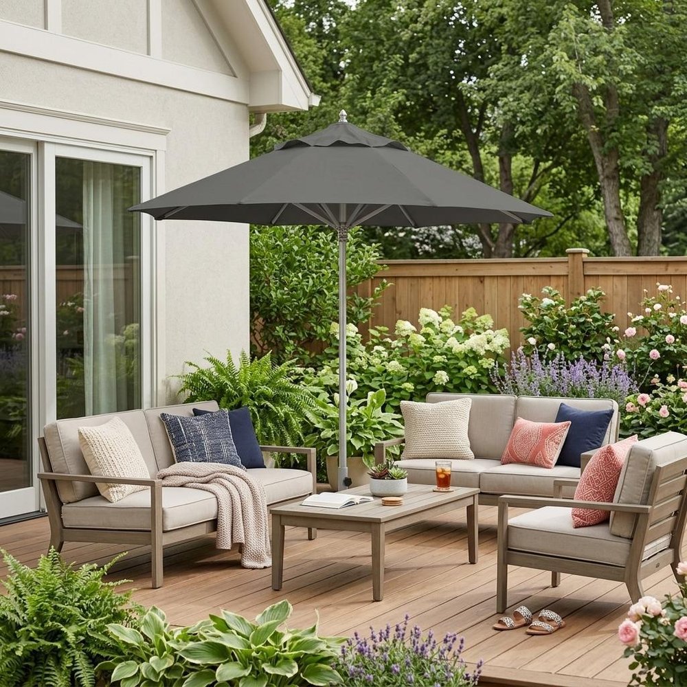 13' Charcoal Polyester Round Tilt Cantilever Patio Umbrella with Stand shown outdoors on a patio with greenery.