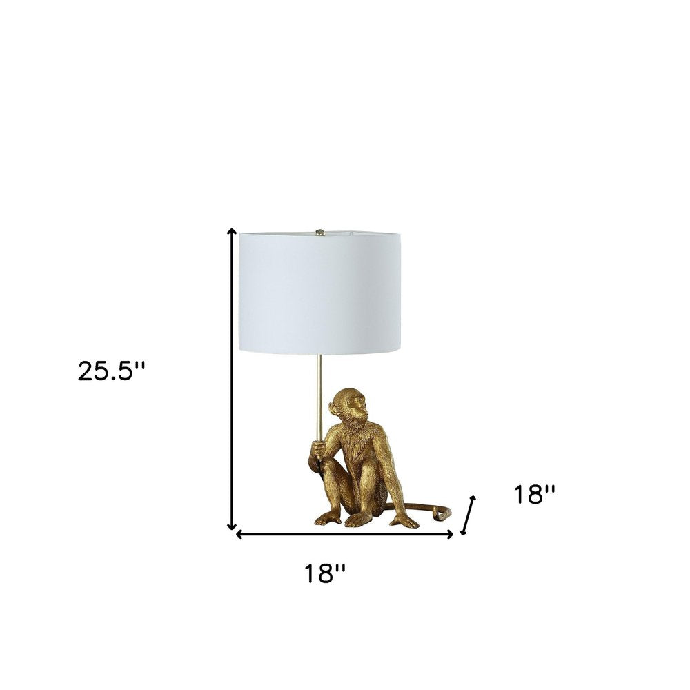 26" Antiqued Gold Sitting Monkey Table Lamp With White. Table lamp isolated on a plain white background, in a gold finish.