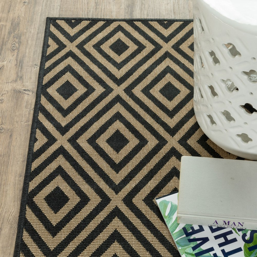 9' X 13' Black and Tan Geometric Stain Resistant Indoor Outdoor Area Rug in a home interior