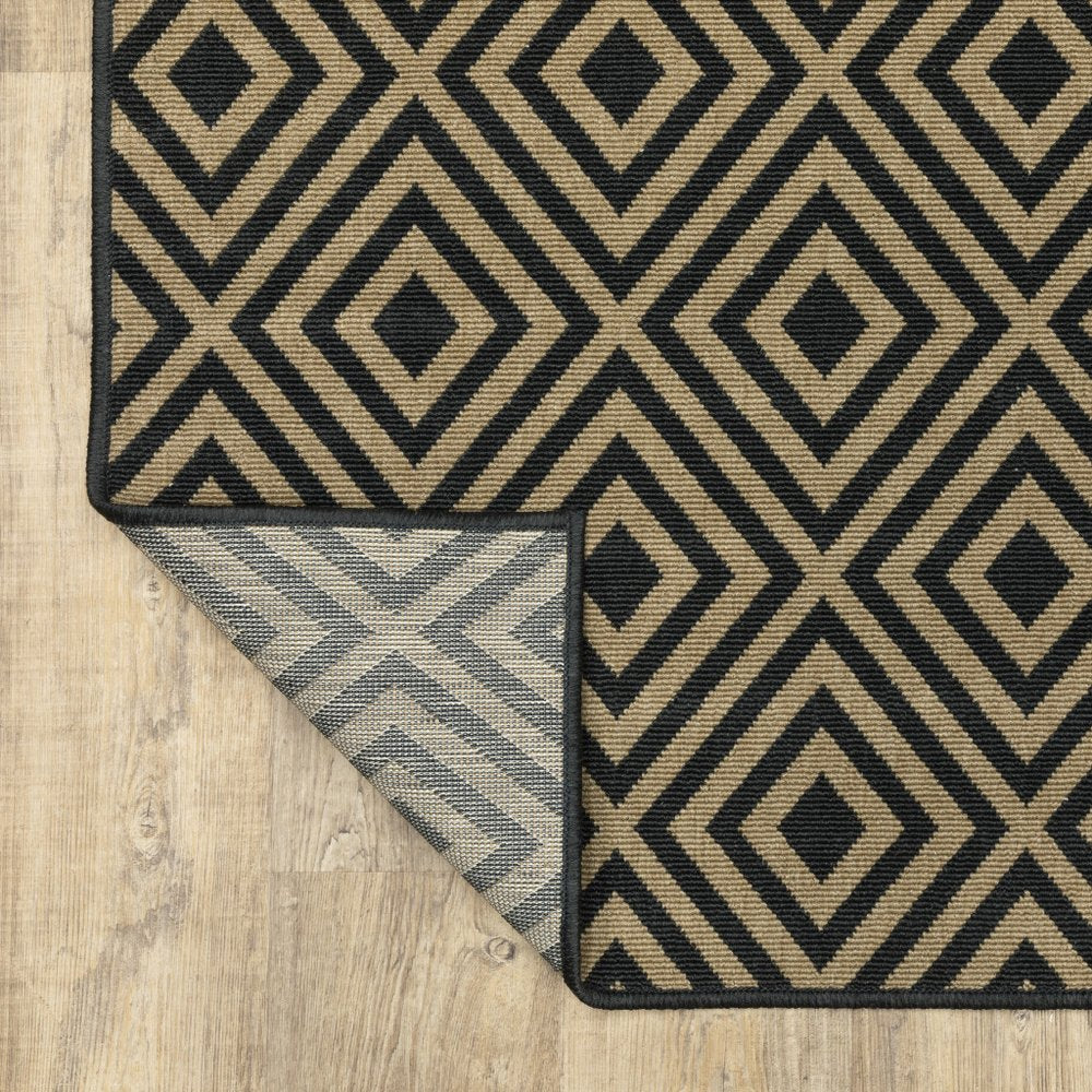 9' X 13' Black and Tan Geometric Stain Resistant Indoor Outdoor Area Rug in a home interior