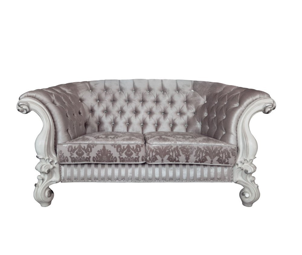 Ivory and off-white velvet loveseat with tufted back and ornate carved wooden frame on a white background.