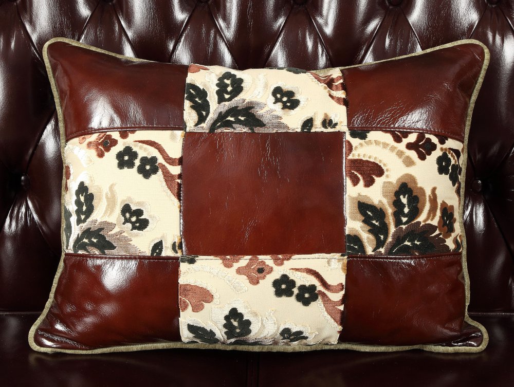 50" Espresso Faux Leather Tufted Wingback Chair And Toss Pillow styled in a furnished interior on a black floor against a burgundy wall in black faux leather.