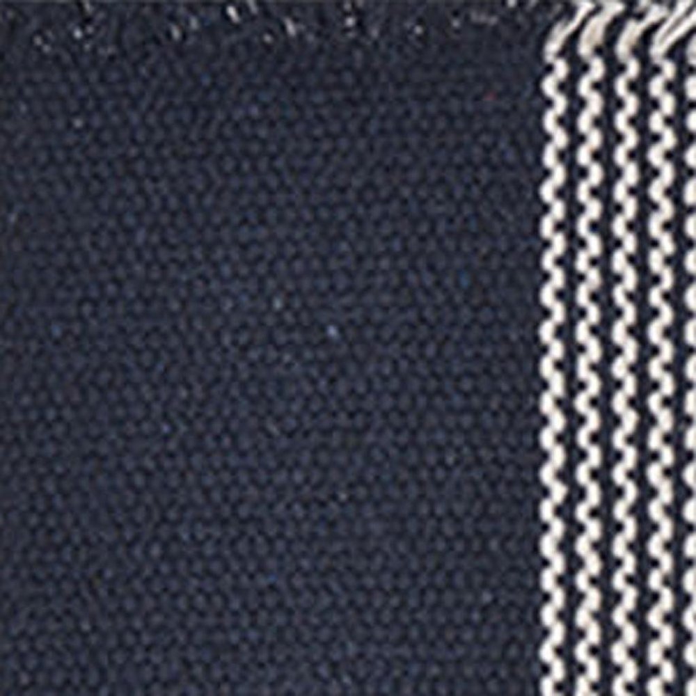 19" Set of Four Navy Blue And White Striped Cotton Placemats styled in a furnished interior with a black wall on a charcoal floor.