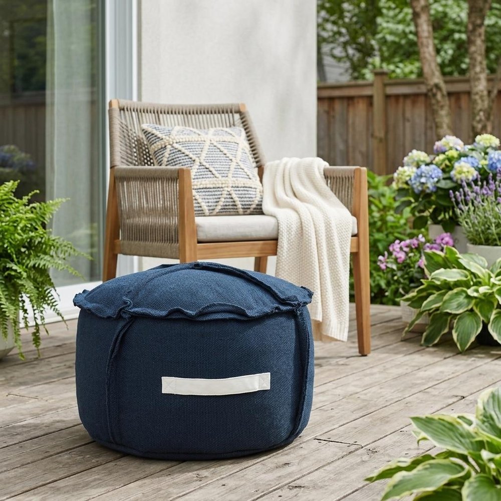 20" Blue Polyester Round Patchwork Indoor Outdoor Pouf Ottoman shown outdoors on a tiled patio with greenery.