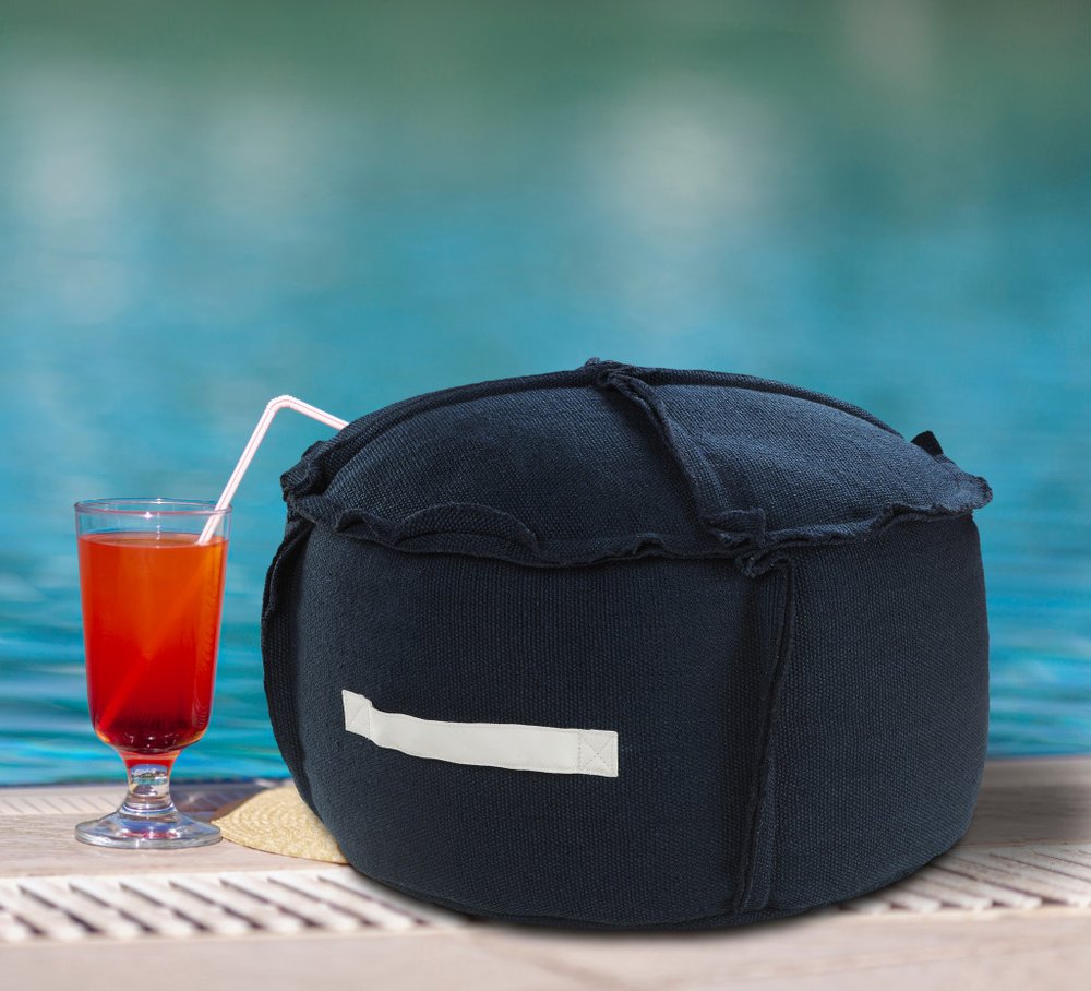 20" Blue Polyester Round Patchwork Indoor Outdoor Pouf Ottoman shown outdoors on a patio with greenery in navy fabric.