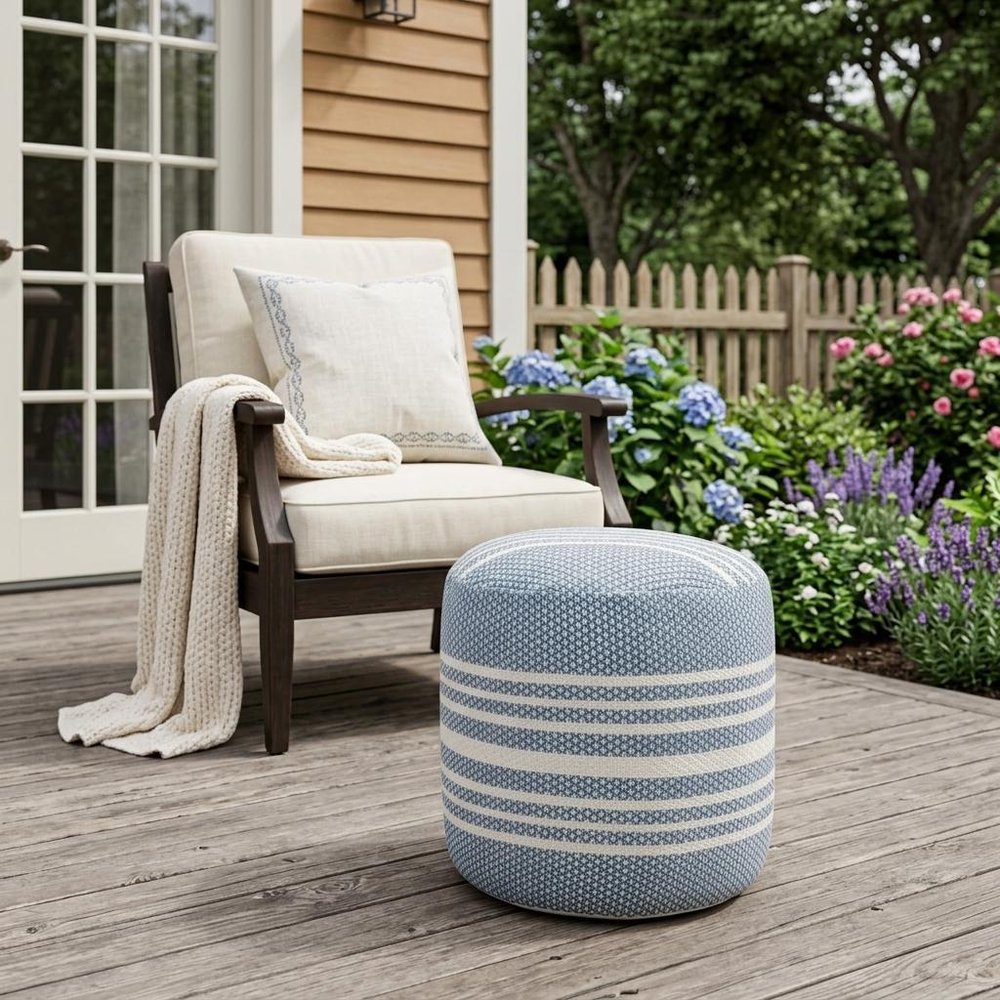 20" Blue Polyester Round Striped Indoor Outdoor Pouf Ottoman shown outdoors on a patio with greenery.