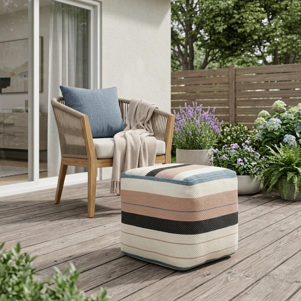 20" White Polyester Striped Indoor Outdoor Pouf Ottoman shown outdoors on a patio with greenery.