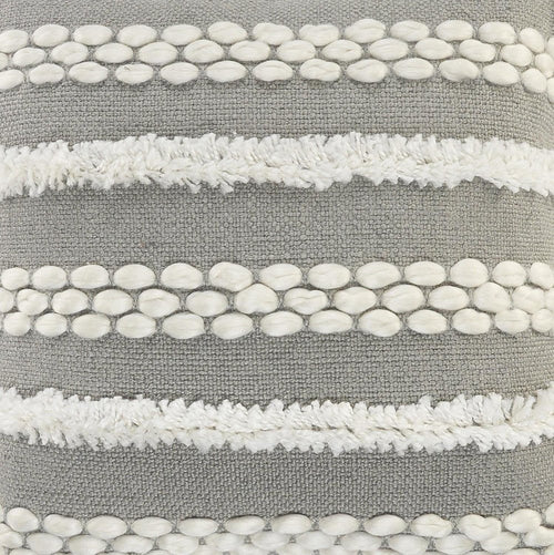 Close-up of a gray throw pillow with horizontal white textured stripes and rows of white oval tufts.