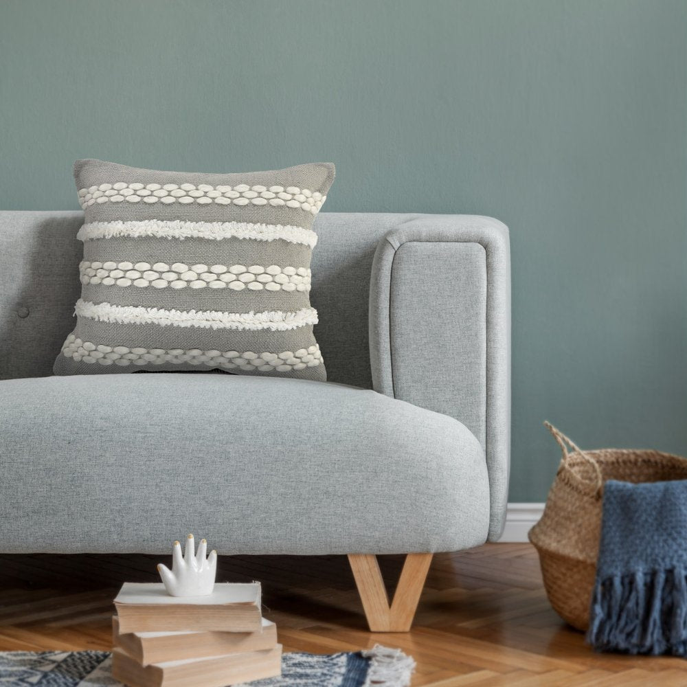 20" Gray and White Geometric Indoor Outdoor Throw Pillow With Texture styled in a furnished interior with a gray wall on a dark wood floor.