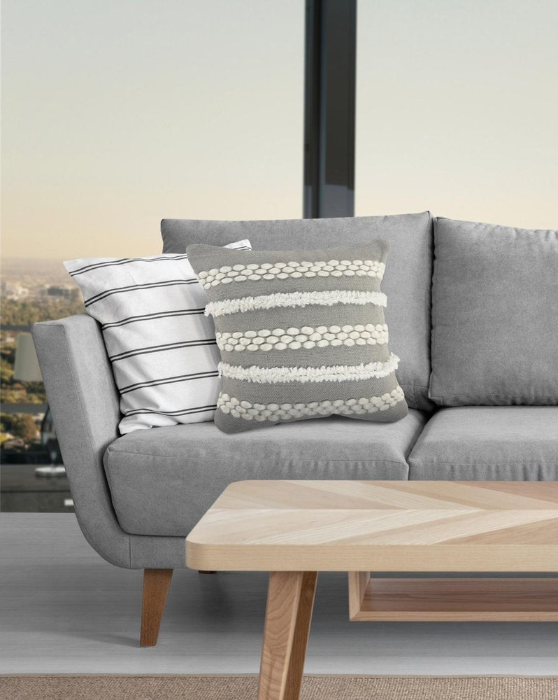 20" Gray and White Geometric Indoor Outdoor Throw Pillow With Texture styled in a furnished interior with an off-white wall on a tiled floor.